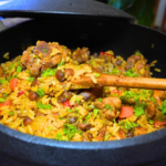 Chicken Pelau by Chef Winston with browned chicken, coconut rice, pigeon peas, and Caribbean herbs