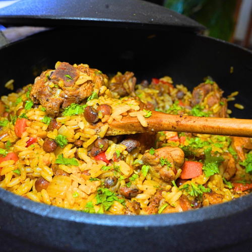 Chicken Pelau by Chef Winston with browned chicken, coconut rice, pigeon peas, and Caribbean herbs