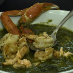 Floribbean Seafood Callaloo by Chef Winston topped with salmon, lobster, shrimp, scallops, and vibrant island greens