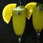 Floribbean Sunrise Mimosa served in a champagne flute with orange garnish by Chef Winston