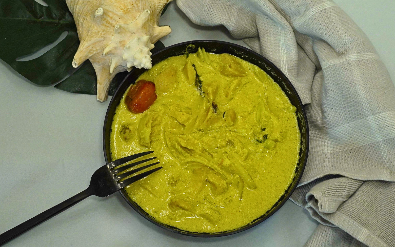 Coconut Curry Conch by Chef Winston served in a creamy coconut curry sauce with fresh herbs and island spices