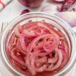 Quick Pickled Red Onions in a mason jar with crisp pink onion slices made with apple cider vinegar, perfect for burgers, tacos, sandwiches, and summer BBQ recipes.